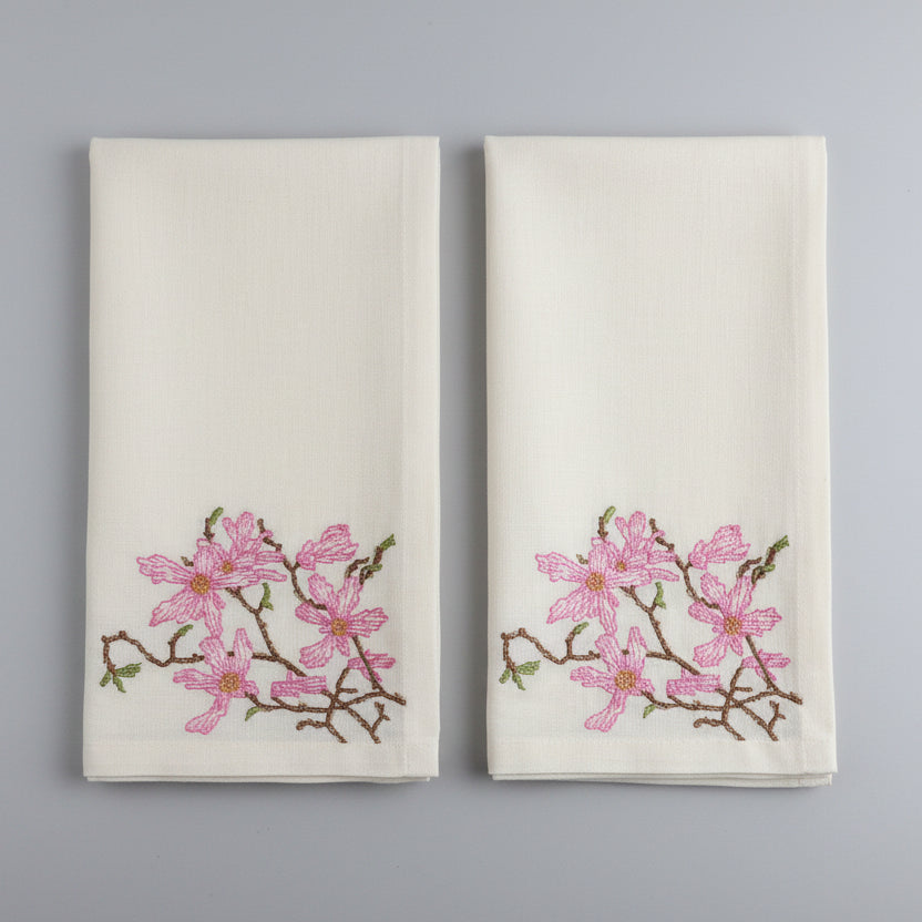 Embroidered fabric with pink floral design on a white background