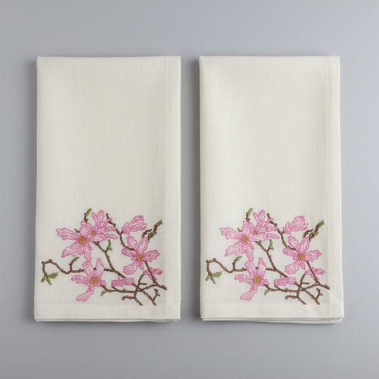 Embroidered fabric with pink floral design on a white background