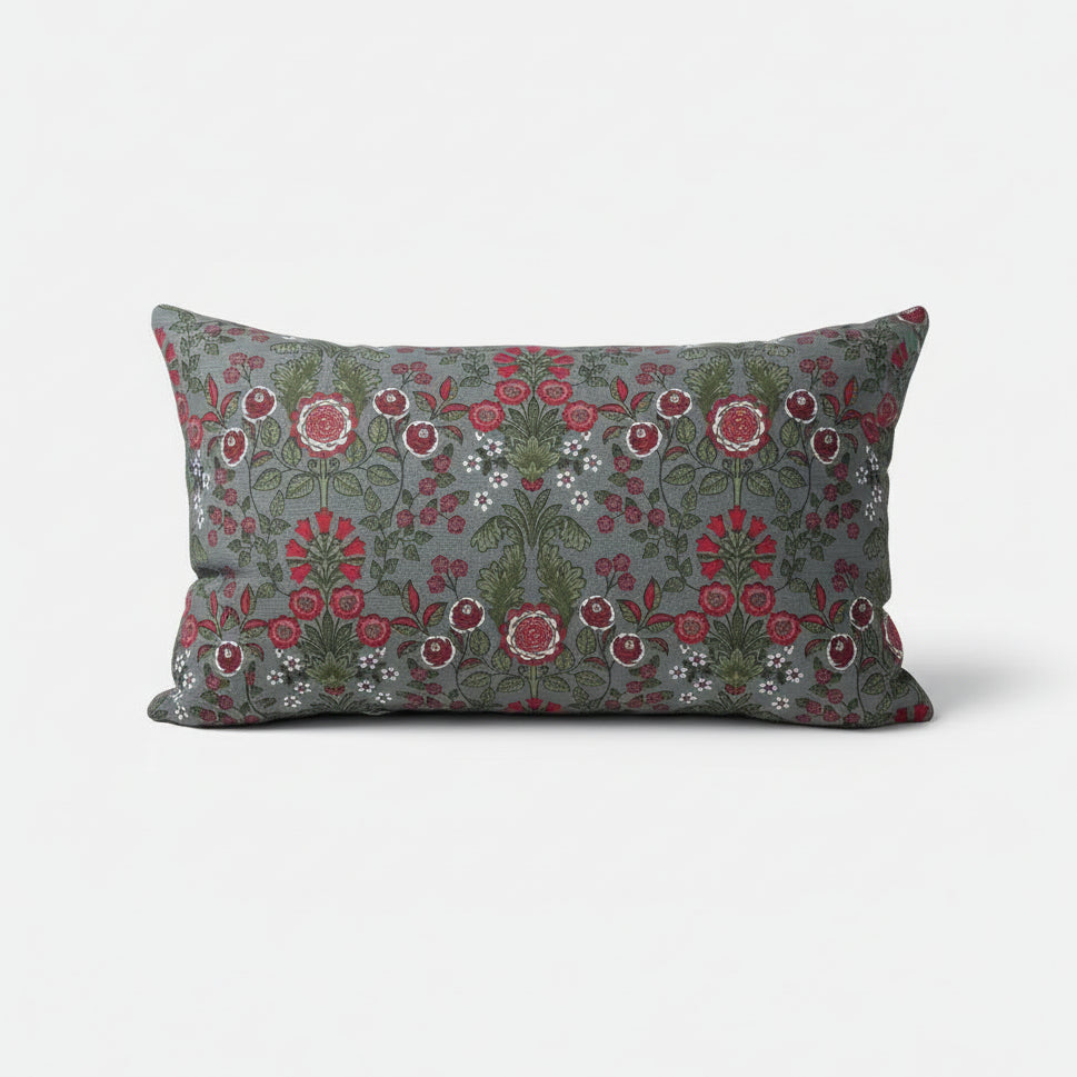 Floral patterned pillow with red and green design on a gray background